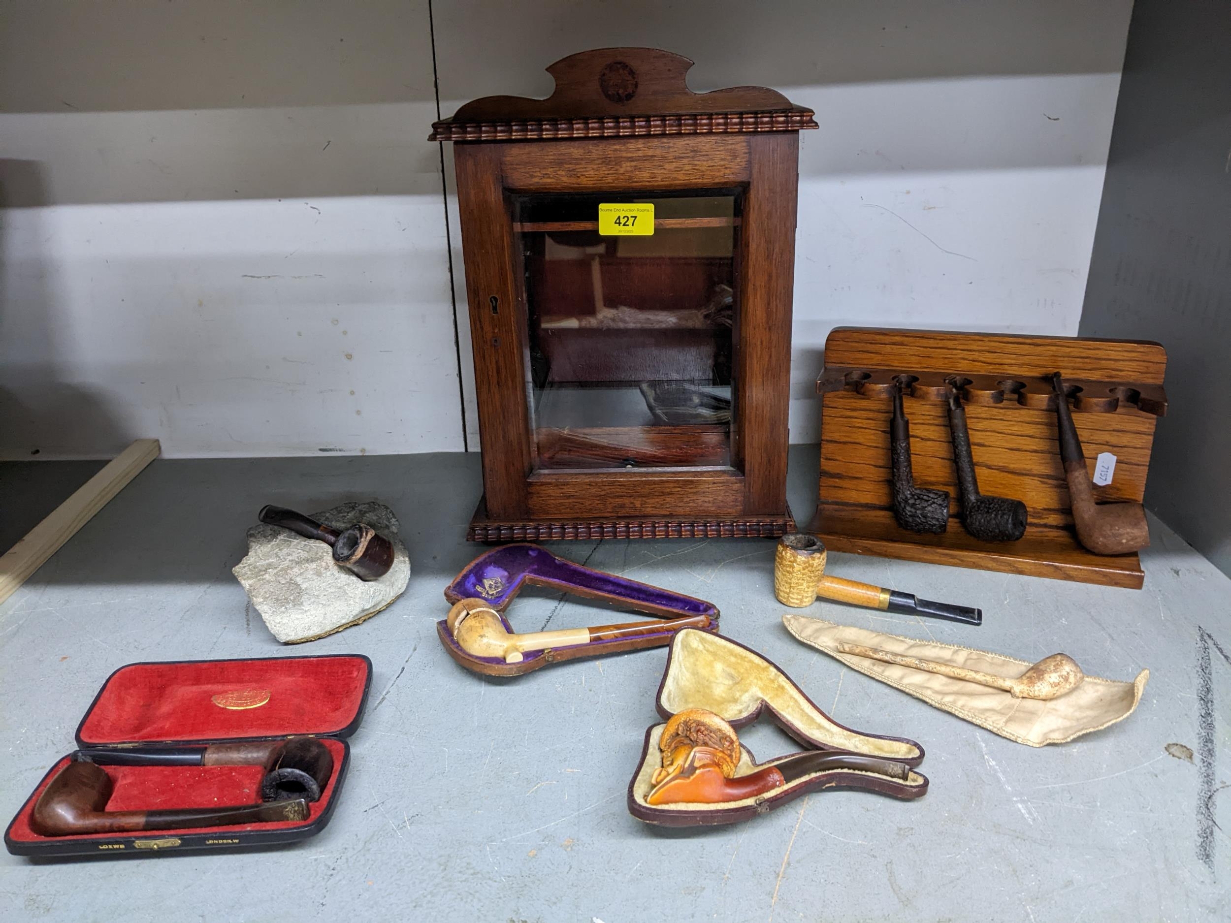 An oak smoker's cabinet with bevelled glass panelled front, fitted interior with drawers, and