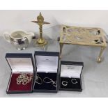 A mixed lot to include a brass trivet stand, trench art, milk jug and boxed costume jewellery