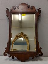 A 19th century mahogany wall mirror in a decoratively carved frame Location: