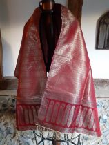 An Indian machine made metallic thread shawl having a red ground with a boteh border and gold