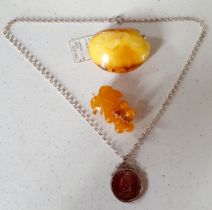 A Modernist Baltic butterscotch amber brooch and a Welsh amber and gold plated brooch fashioned as a