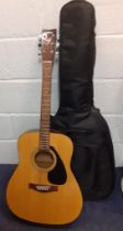 A Yamaha F-310 6-string acoustic guitar with soft padded case.
