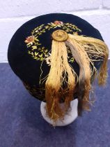 A late 19th/early 20th Century hand-sewn black velvet smoking cap with yellow embroidered floral