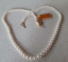 A string of Mikimoto cultured graduating pearls having an 18ct gold bow design clasp, 41cm long with