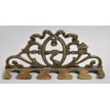 A Brass Wall Mounting Pipe Rack with Scrolled Design Incorporating Ribbons, Rope and a Pipe, 19cms