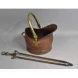 A Copper and Brass Helmet Shaped Coal Scuttle and a Pair of Long Handled Brass Fire Tongs