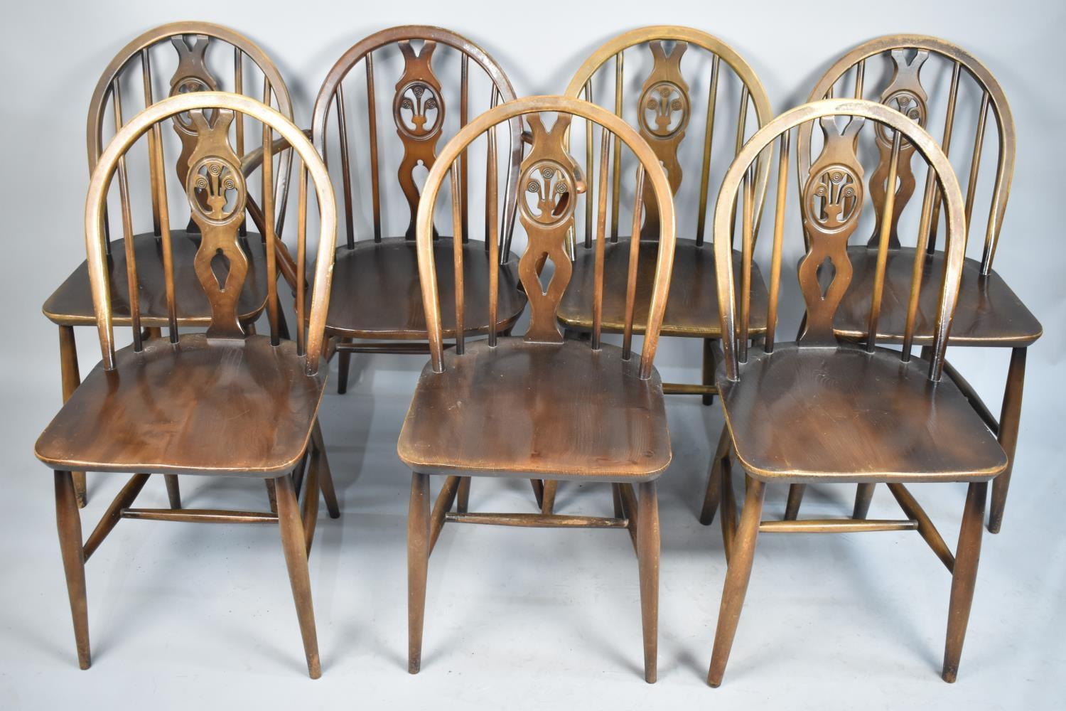 A Set of Seven Ercol Hoop Back Fleur De Lys Chairs to Include One Carver