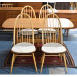 An Ercol Rectangular Dining Table and Four Ercol Quaker Hoop Back Chairs