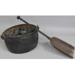 A Vintage Cast Iron Cooking Pot Containing Anthracite Together with a Cast Iron Fire Shovel