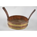 A Brass Banded Circular Oak Bowl with Two Carrying Handles, 28cms Diameter