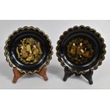 A Pair of Chinese Lacquered Circular Scalloped Edged Dishes decorated with Monks Playing in