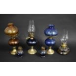 A Collection of Various Brass and Coloured Glass Reservoir Oil Lamps