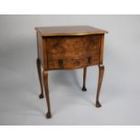 A Mid 20th Century Burr Walnut Lift Top Sewing Box on Cabriole Supports with Carved Claw Feet,
