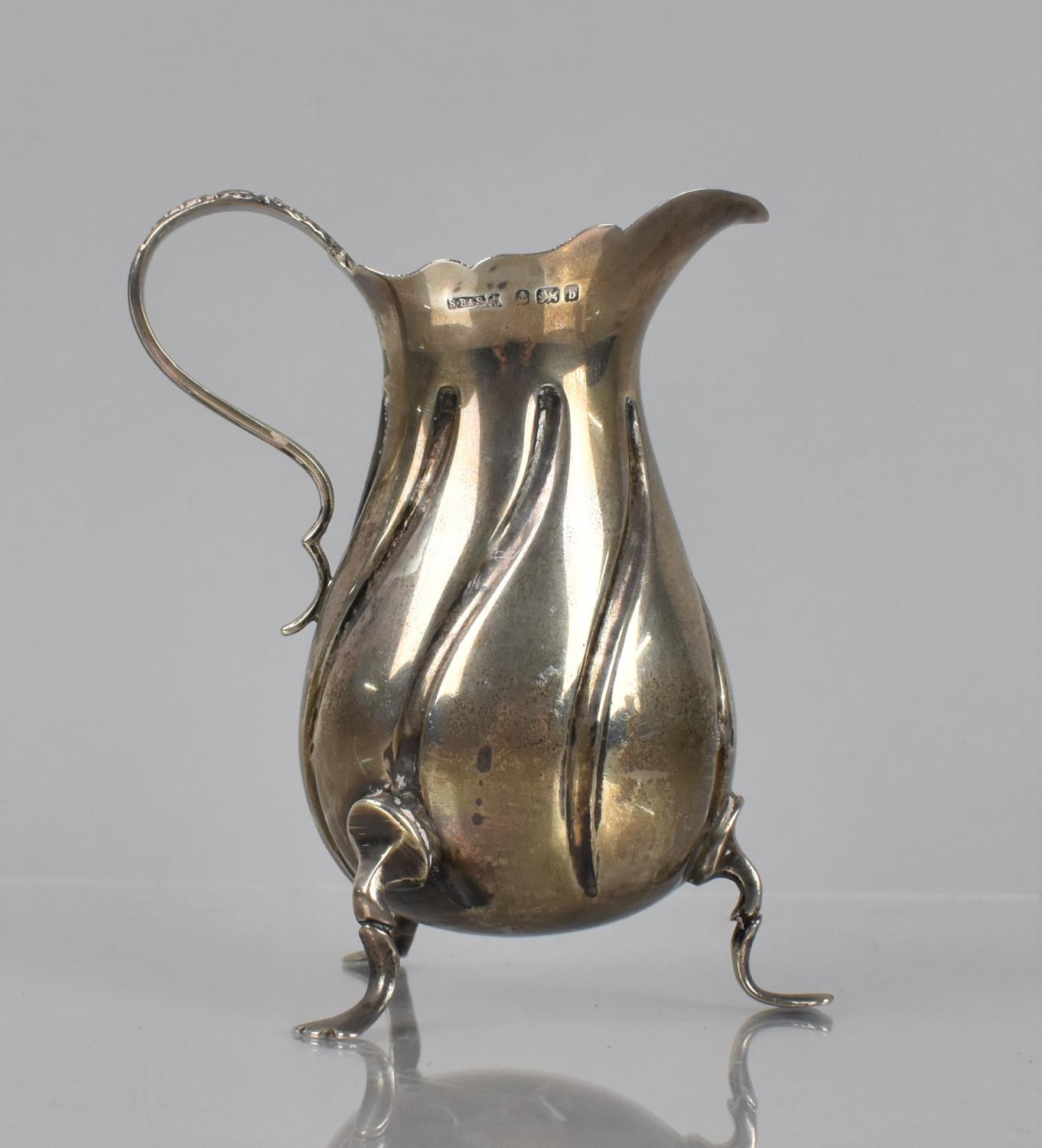 An Edward VII Silver Cream Jug of Wyrthen Form raised on Tripod Pad Feet with Scrolled Handle by