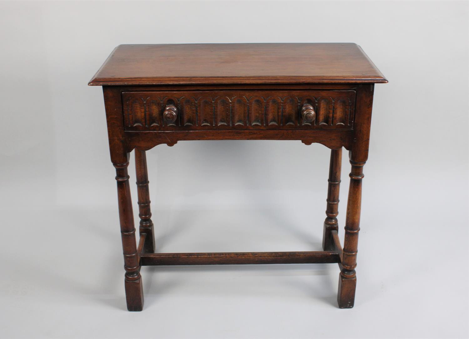 A Mid 20th Century Oak Side Table with Single Drawer having Carved Front, Turned Supports, 76cms