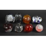 A Collection of Eight Large Coloured Glass Paperweights