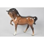 A Beswick Brown Horse Model No. 1549 (Head Tucked, Leg Up), First Version
