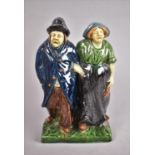 A Continental Figure group, C.1900, Modelled as Elderly Couple Walking Arm in Arm, 19cm high