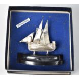 A Middle Eastern Sterling Silver Model of a Two Masted Dhow on Oval Ebonized Plinth, 11cms Wide