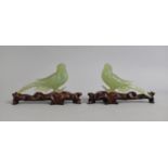 A Cased Chinese Boxed Pair of Jade Effect Birds on Wooden Stands, Both with Condition Issues