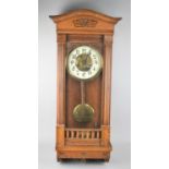 An Edwardian Oak Framed Eight Day Wall Clock, the Glazed Hinged Front Opening to Enamel Face with