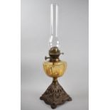 A Late Victorian Oil Lamp with Cast Pierced Metal Base, Amber Glass Reservoir and Plain Chimney,