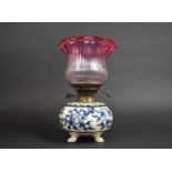 A Ceramic Based Oil Lamp with Nice Quality Ribbed and Reeded Cranberry Glass Shade, 33cm high