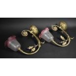 A Pair Early 20th Century Ornate Brass Wall Lights with Frosted Cranberry Glass Shades, the Frames