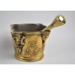 An Early Brass Pestle and Mortar, Decorated with Fleur De Lys in relief and Mask Head Recesses,