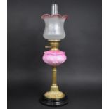 A Late Victorian Brass Based Oil Lamp with Ribbed Column on Circular Plinth, Pink Glass Reservoir
