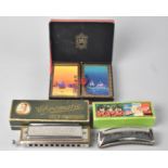 A Cased Koch Harmonica, Weiss Three Little Boys Harmonica and a Cased Pair of De La Rue Playing