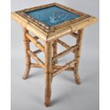 A Vintage Square Topped Bamboo Occasional Table with Inset Tile Depicting Duck Shooting From Punt,