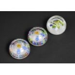 Three Perthshire Glass Paperweights, Two Prince of Wales Feathers and One Pansy on Latticino Cushion