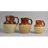 Three Various 19th/20th Century Glazed Stoneware Jugs, Two Decorated in Relief and the Other with