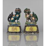 A Pair of Japanese Porcelain Temple Lions on Tapering Plinth Bases decorated in Polychrome