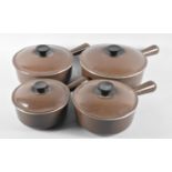 A Graduated Set of Four Brown Le Creuset Lidded Cooking Pans