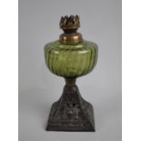 A Late Victorian Oil Lamp Base having Green Glass Reservoir on Cast Iron Stand with lion Mask