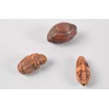 A collection of two miniature oriental carved nut netsukes together with a miniature carved nut