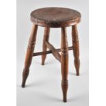 An early 20th century circular topped four legged stool, 46 cm high.