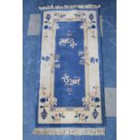 A Chinese Patterned Woollen Rug on Blue Ground, 140x71cm