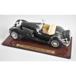 A Burago Model of a Mercedes Benz 500k on Sloping Wooden Plinth, 27cm wide