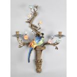 A Bronze and Porcelain Two Branch Wall Hanging Candelabra in the form of Parrot Perched Amongst