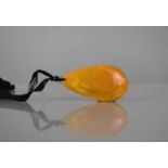 A Large Egg Yolk Amber Pendant on Black Silk Ribbon, Possibly 19th Century, Pear Shaped Pendant