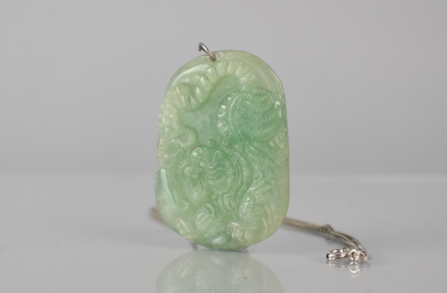 A Jade Pendant on Silver Chain, Panel Depicting Pouncing Tiger in Relief amongst Flowers and Foliage - Image 2 of 3