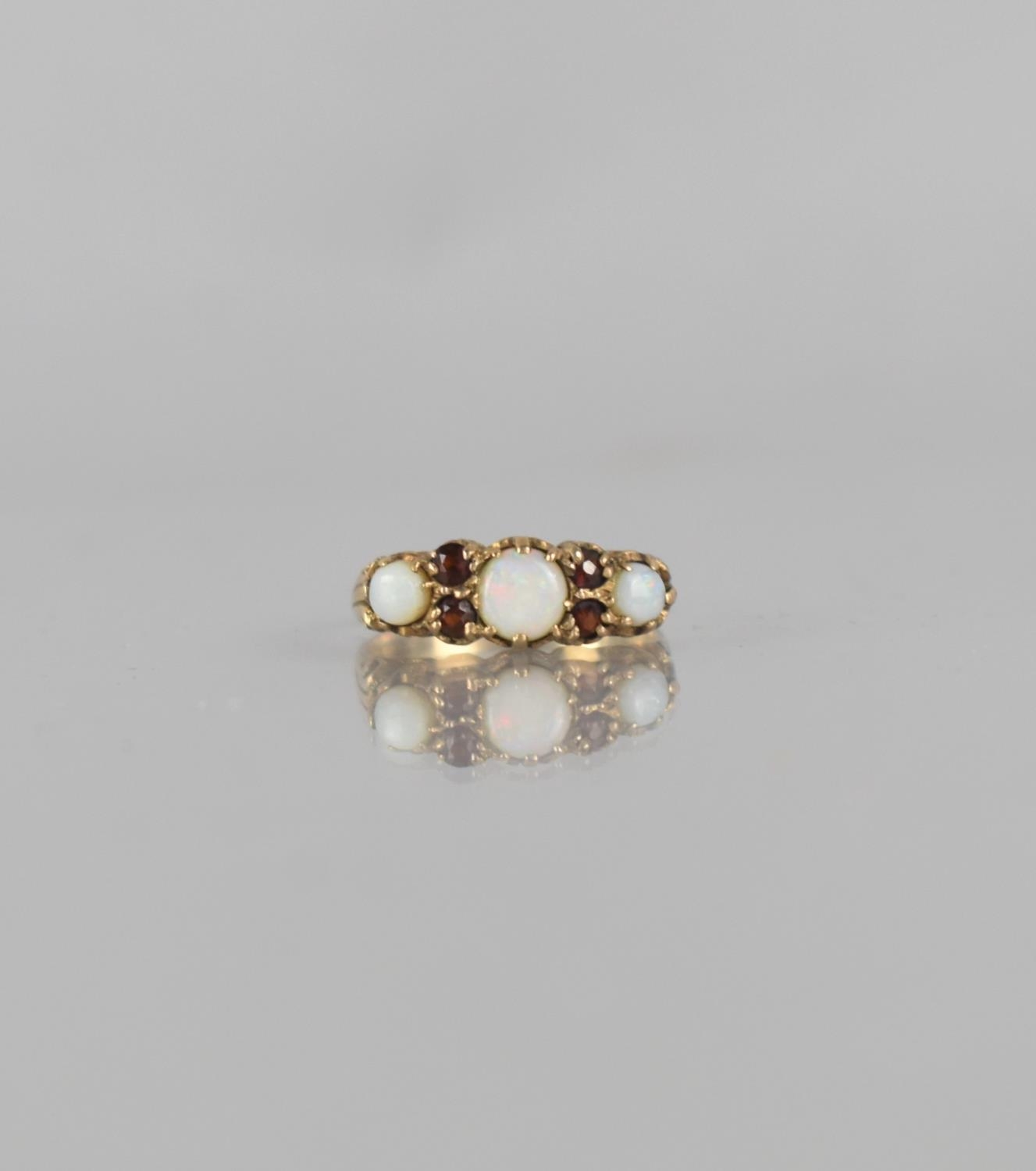 A 9ct Gold, Opal and Garnet Dress Ring, Centre Round Cabochon Opal Measuring 5mm Diameter, Claw