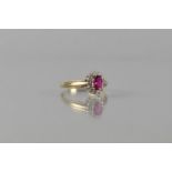 A Ruby, Diamond and 9ct Gold Cluster Ring, Central Oval Cut Ruby Measuring 6mm by 4mm, Raised in