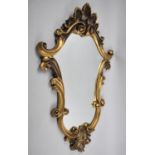 An Ornate Gilt Framed Wall Mirror if Shaped Scrolled Form