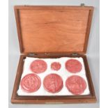 A Cased Set of Five Pink Glazed Plaster Copies of Legal Document Seals