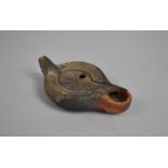 A Terracotta Oil Lamp with Incised Decoration, Some Chips, 13cms Long