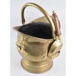 A Mid 20th Century Brass Helmet Shaped Coal Scuttle with Shovel, 46cms High